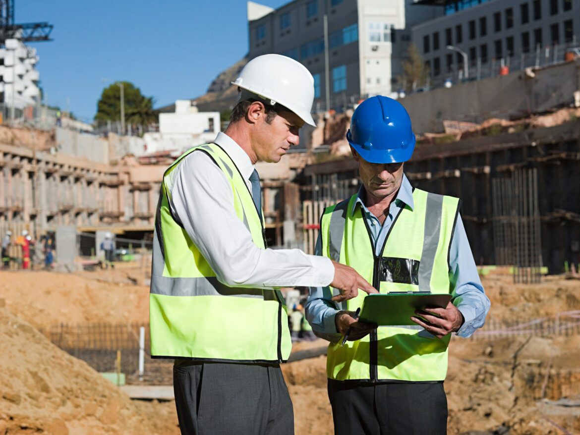 Mature men with clipboard on construction site Mature men with clipboard on construction site